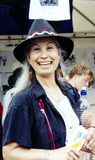 Smiling person with rainbow earrings at San Diego Pride, 1995